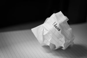 crumpled up paper with "ideas" written on it