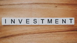 wooden block letters spell out "investment"