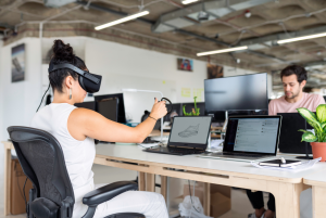 Woman Using Laptop Computer With VR Headset