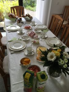 a very formal breakfast table with meats, cheeses and breads