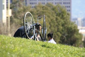 man repairing a bike in the park