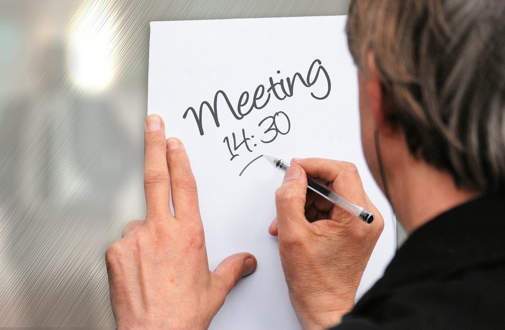 Meeting 14:30 (person making a sign)