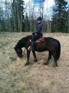 A young girl is riding a horse