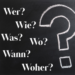 Chalk board with question words: Wer? Wie? Was? Wo? Wann? Woher?