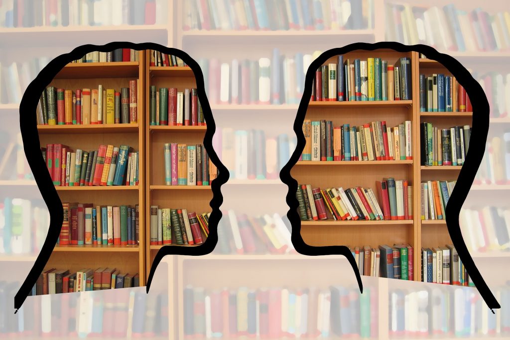 Two clear silhouettes facing each other in front of bookshelves.
