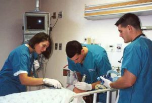 image of respiratory therapist working on a patient, intubating , auscultating and preparing to ventilate