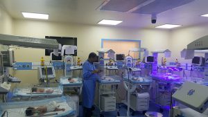 NICU with multiple babies and a nurse providing care