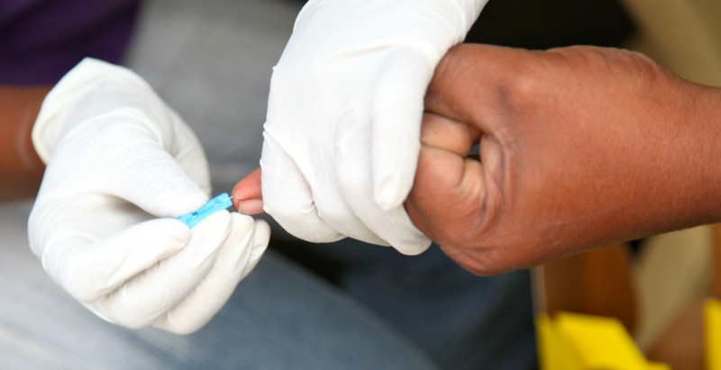 Phlebotomist performing a capillary stick on fingers