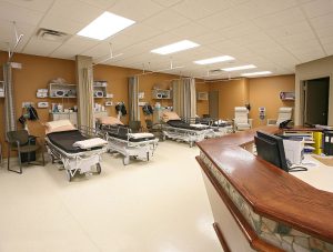 empty recovery room with four beds and a desk
