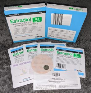 Two boxes and exmaples of Estradiol transdermal patches