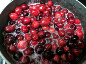 cranberries being cooked in a pot