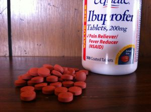 Bottle and 200 mg red tablets of Ibuprofen