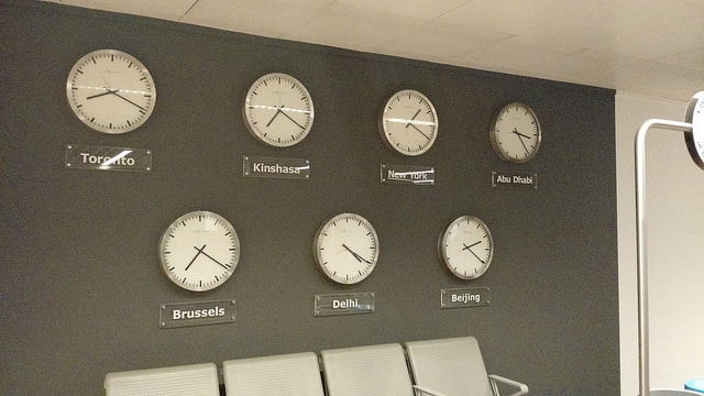 1.4.0- Descriptive image showing seven clocks on a wall, each representing a different time zone.