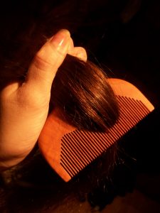 Descriptive image showing a close up of hair being combed.