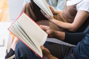 Descriptive image showing two people reading books.