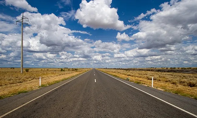 "A photograph shows an empty road that continues toward the horizon.