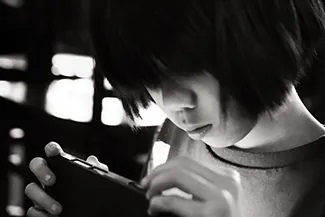 src="https://openstax.org/resources/be42f4fd1d154154acbda8fdb5ce6386e44bff1c" alt="A photograph shows a young person looking at a handheld electronic device.